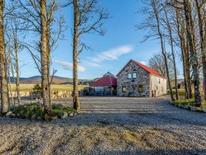 a barn with a red roof in the middle of trees at 4 Bed in The Cairngorms 80298 in Knockandhu