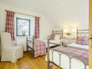 a bedroom with two bunk beds and a chair at 4 Bed in The Cairngorms 80298 in Knockandhu