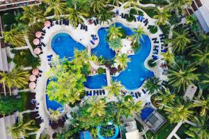 スリンビーチにあるHoliday Inn Resort Phuket Surin Beach, an IHG Hotelのヤシの木が植わるリゾートのスイミングプールの空中ビュー
