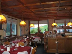 una sala da pranzo con tavoli, sedie e lampadari di Gasthof Talblick a Ischgl