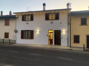 Casa blanca con persianas marrones y una calle en B & B Giu & Dany, en Bruscoli