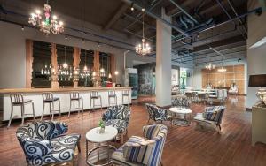 a lobby with a bar with chairs and tables at Delonix Hotel Karawang in Karawang