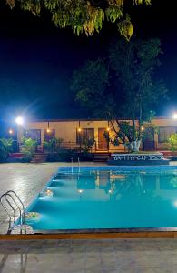 a large swimming pool at night at Ashoka Lawns and Resort in Alibaug