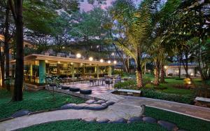 a building with a courtyard with tables and trees at Delonix Hotel Karawang in Karawang