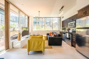 a living room with a couch and a kitchen with windows at Luxury Suite in Downtown Toronto in Toronto