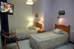 Postel nebo postele na pokoji v ubytování Hotel El Emigrante