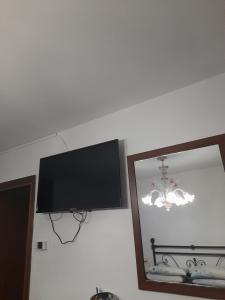 uma televisão de ecrã plano numa parede ao lado de um espelho em Beb san giorgio em Volpino