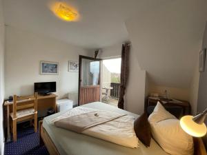 ein Hotelzimmer mit einem Bett, einem Schreibtisch und einem Fenster in der Unterkunft Hotel Sonnenhof in Obersuhl