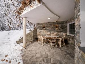 un patio con mesa y sillas en la nieve en Relax Inn en Angerberg