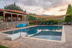 einen Pool mit Hängematte neben einem Haus in der Unterkunft Villa Gaia in Mílatos