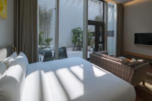 - une chambre avec un lit et un salon dans l'établissement Wuyu Hotel Chongqing Yangjiaping The Mixc, à Chongqing