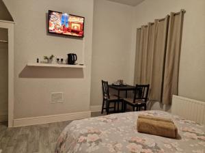 a bedroom with a bed and a table with chairs at ArklesFCLiverpool in Liverpool