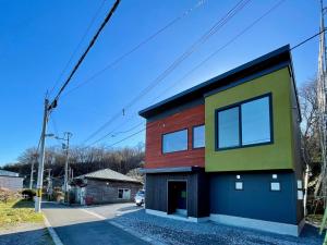 uma casa com uma fachada colorida numa rua em Hakodate 函館 時のたつままに-sauna stay- em Hakodate