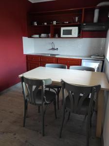 een keuken met een tafel en stoelen en een magnetron bij PenichePraia - Bungalows, Campers & SPA in Peniche