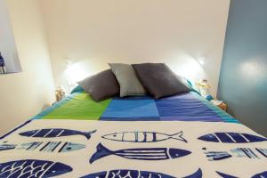 a bed with a colorful blanket with fish on it at La Calata - Monolocale in Portoferraio