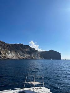 un bateau dans l'eau avec une montagne en arrière-plan dans l'établissement Villa G, à Mesariá