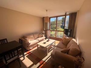una sala de estar con un sofá y una mesa en Vistas Sobrellano, en Comillas