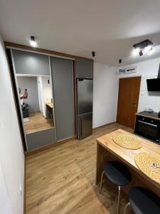 een kamer met een keuken met een tafel en een koelkast bij Dziupla in Orneta