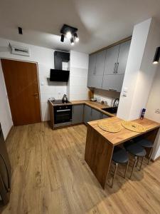 a kitchen with a wooden table and chairs in it at Dziupla in Orneta