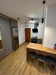 Una cocina con una mesa de madera y dos sillas. en Dziupla, en Orneta 4 fotos más