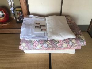 uma cama com duas almofadas em cima em 城跡石垣上の絶景古民家宿 鞆城茶屋庵 em Tomo