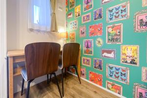 two chairs sitting at a table with a wall of pictures at MAT WASEDA in Tokyo