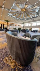 eine große Lobby mit einem großen Sofa und Stühlen in der Unterkunft Grand Mercure Hotel Hualing in Ürümqi