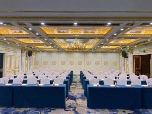 un salón de banquetes con mesas azules y sillas blancas en Grand Mercure Hotel Hualing en Ürümqi