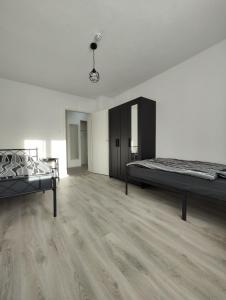 a white room with two beds and a wooden floor at Silverstar in Sindelfingen