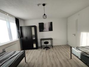 Habitación con 2 camas, mesa y espejo. en Silverstar, en Sindelfingen