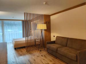 ein Wohnzimmer mit einem Sofa und einem Bett in der Unterkunft Hotel Ideal in Madonna di Campiglio