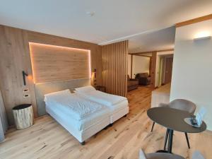 1 dormitorio con cama, escritorio y mesa en Hotel Ideal, en Madonna di Campiglio