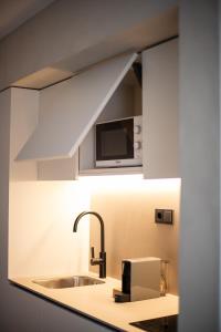 a kitchen with a sink and a microwave at Apartamentos Top Secret Es Pujols - Formentera Vacaciones in Es Pujols