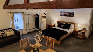 a bedroom with a bed and a couch and a table at The Old Vicarage in Flore