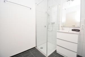 a white bathroom with a shower and a sink at Ferienwohnung in Hard am Bodensee in Hard