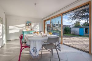 a dining room with a white table and chairs at Pause, detente et partage a Pornichet in Pornichet