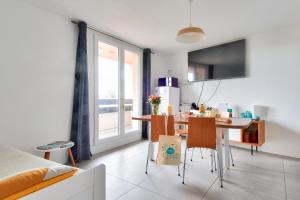 una cucina e una sala da pranzo con tavolo e sedie di Douce echappee a Noirmoutier-en-l ile a Noirmoutier-en-l'lle