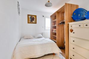 ein Schlafzimmer mit einem Bett und einer Kommode in der Unterkunft Appart pour 4 dans domaine avec piscine in Noirmoutier-en-l'lle + 6 Fotos