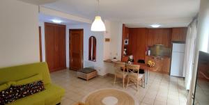 a living room with a yellow couch and a kitchen at Casa Felix - Ferienwohnung in Esquinzo in Playa Jandia