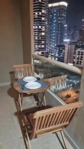 a table and chairs on a balcony with a view of a city at Marina View Manchester tower in Dubai