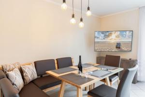 a dining room with a table and a couch at Wellness-Ferienwohnung Strandurlaub Baabe in Baabe