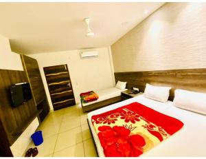 Habitación de hotel con cama con manta roja en Bajaj Regency, Ludhiana, en Ludhiana