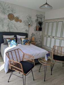 ベルジュラックにあるLe Domaine de La Tour des Ventsのベッドルーム1室(ベッド1台、椅子2脚、テーブル付)