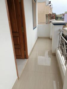 a hallway with a door and a tile floor at VJ VILLA HOME STAY PURPLE ROOM in Puducherry