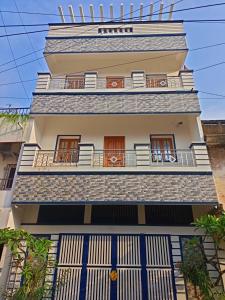 a building with blue doors and a balcony at VJ VILLA HOME STAY PURPLE ROOM in Puducherry