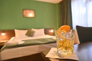 a glass of water on a table next to a bed at Hotel Ida in Bansko