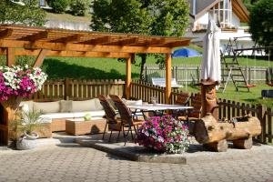eine Terrasse mit einem Tisch und einem hölzernen Pavillon in der Unterkunft Gästehaus Rettenbacher in Fulpmes