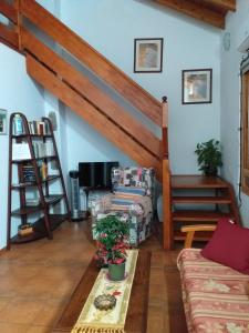 a living room with a couch and a staircase at Casa Rural Carmita in Vega de San Mateo