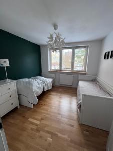 - une chambre avec 2 lits et un mur vert dans l'établissement Krynica Zdrój Apartament 4 pokoje, à Krynica-Zdrój