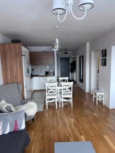 Il comprend un salon et une cuisine avec une table et des chaises. dans l'établissement Krynica Zdrój Apartament 4 pokoje, à Krynica-Zdrój